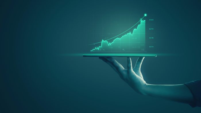businessman holding tablet showing holographic graphs stock market statistics gain profits scaled